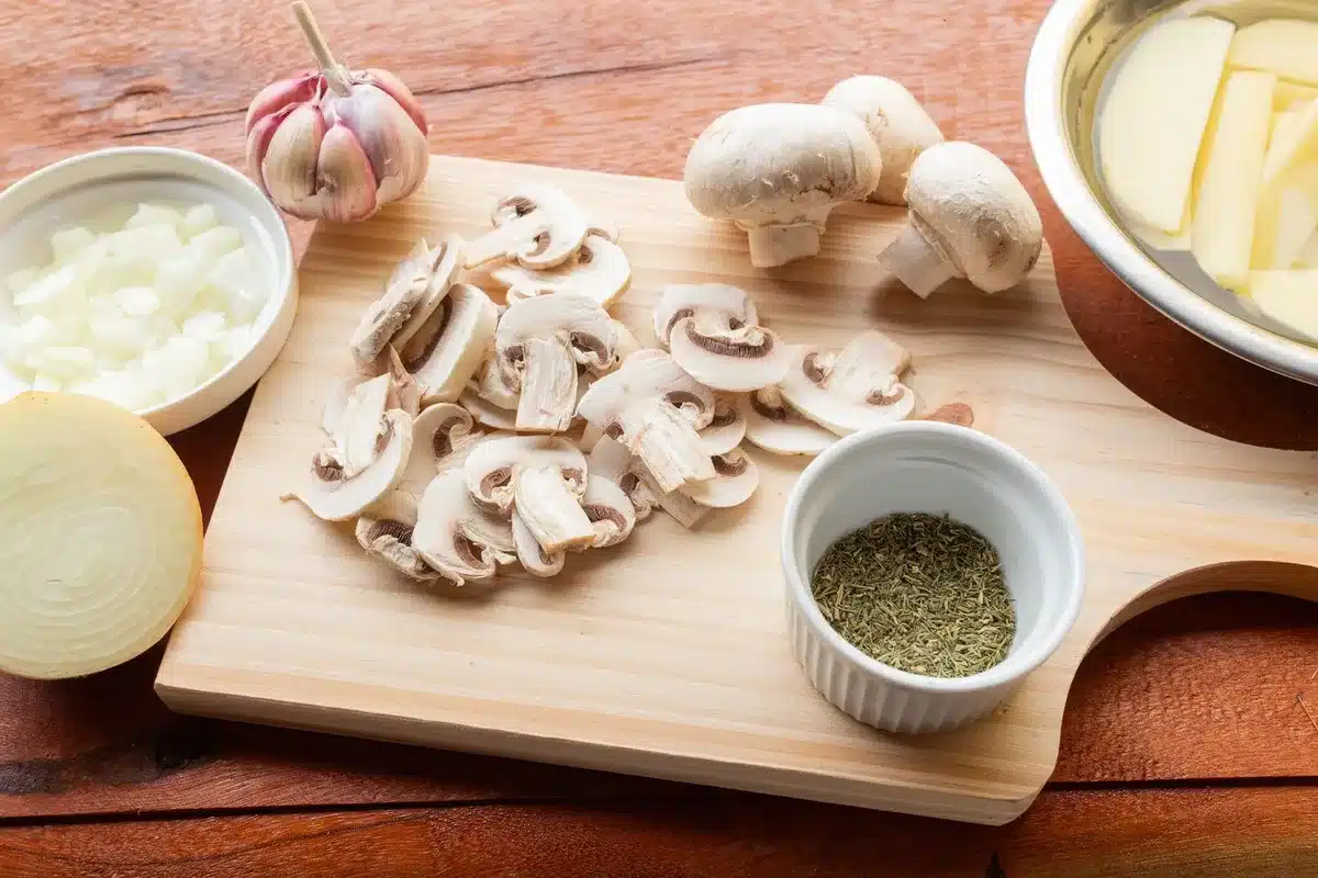 Ingrédients frais pour le velouté : champignons de Paris, oignon et cube de bouillon