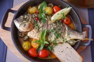 Fenouils braisés à la tomate et aux olives, servis dans un plat méditerranéen.