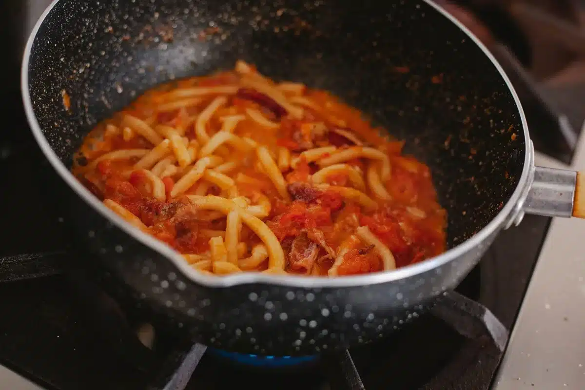 Sauce à base de lait de coco et tomates en dés mijotant dans une poêle