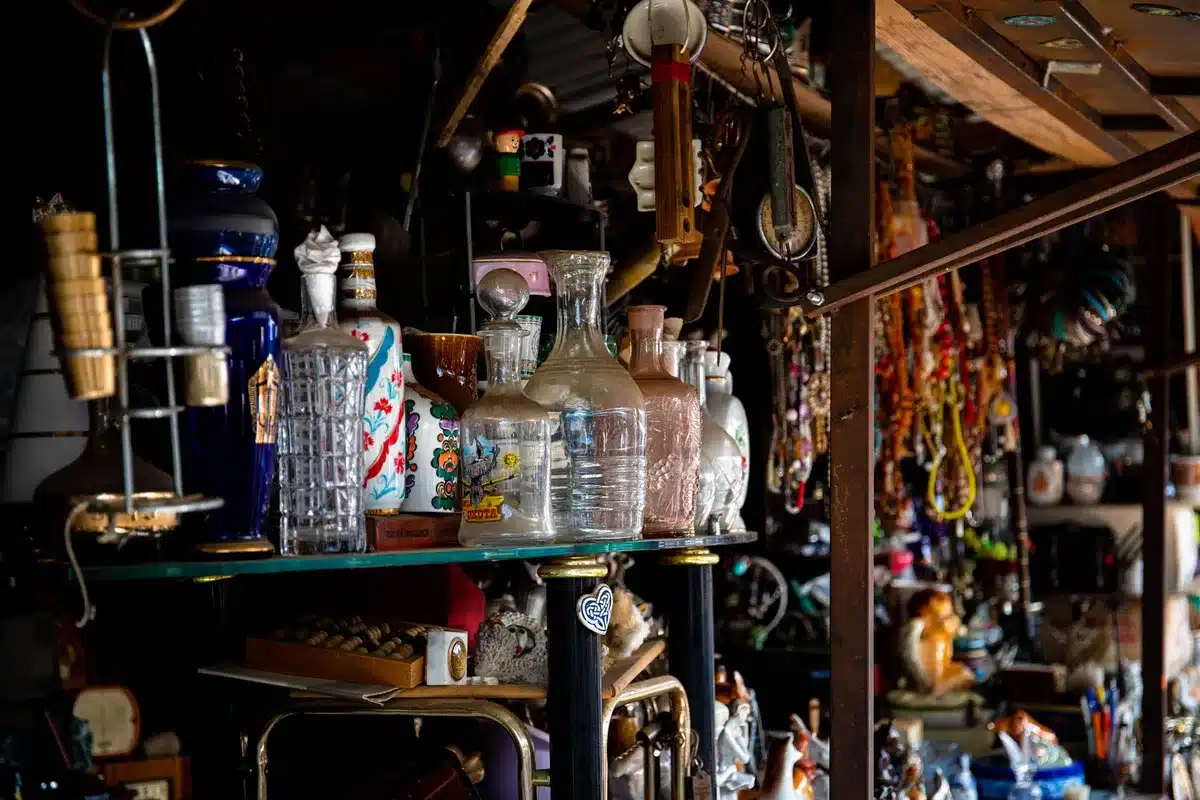 Marché aux puces avec étals de verres et objets vintage colorés