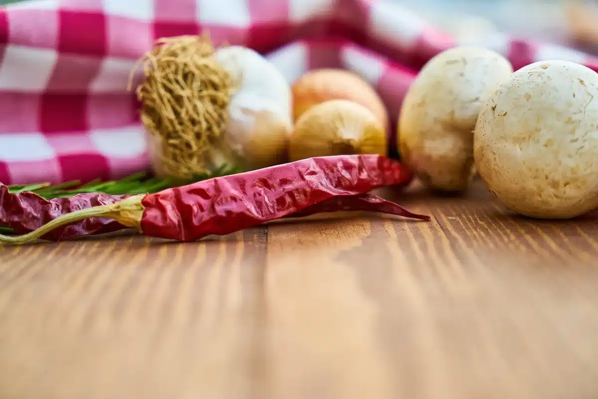 Ail et oignon émincés sur une planche de cuisine avec un couteau