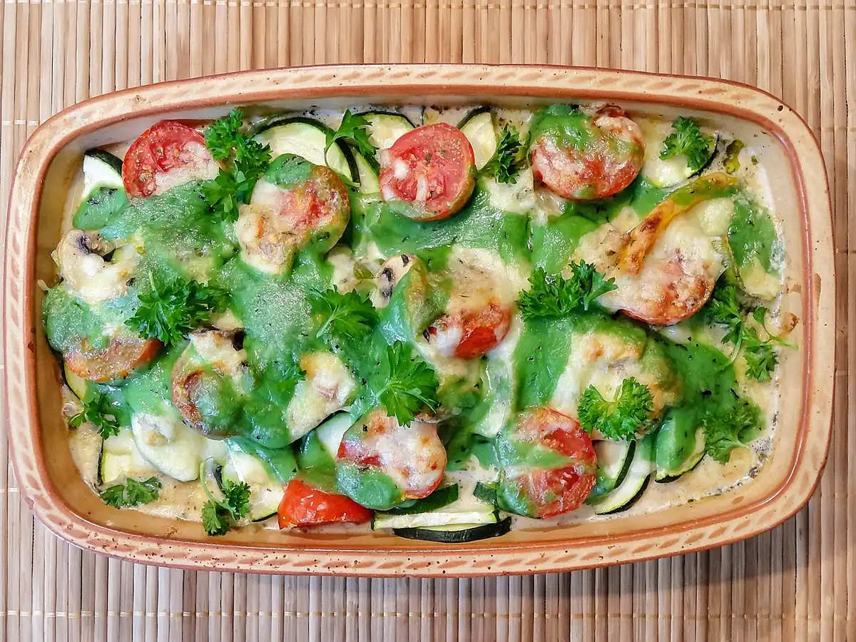 Plat à gratin rempli de couches alternées de légumes, viande et sauce béchamel.