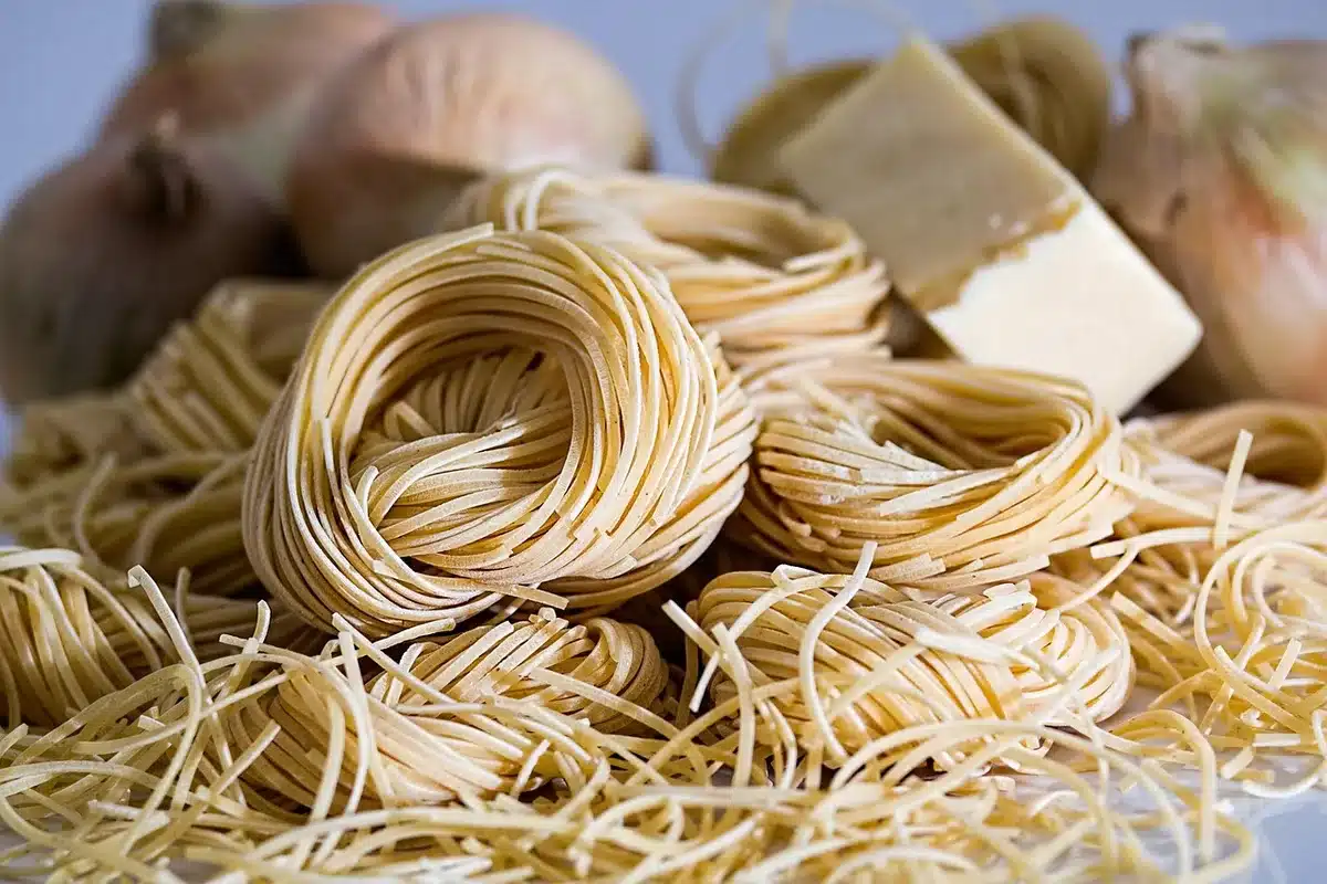 Les pâtes et ingrédients cuisent ensemble dans une poêle avec un ustensile de cuisine