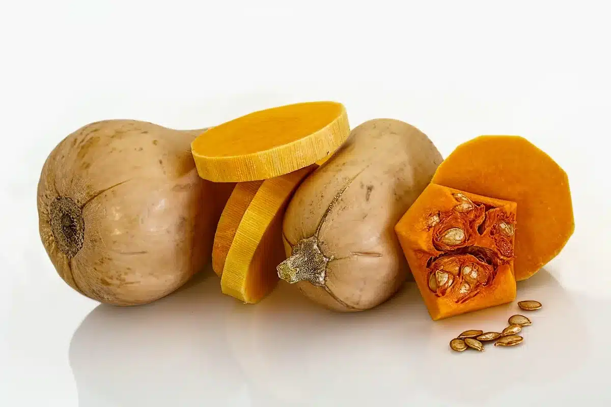 Ingrédients pour la soupe de potiron : potiron, oignon et autres ingrédients sur une planche.