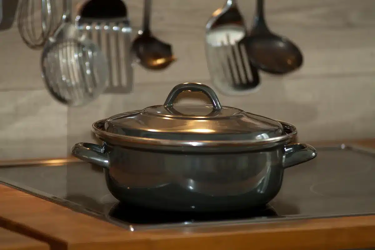 Casserole sur la cuisinière et cuillère en bois montrant le mélange en train de cuire