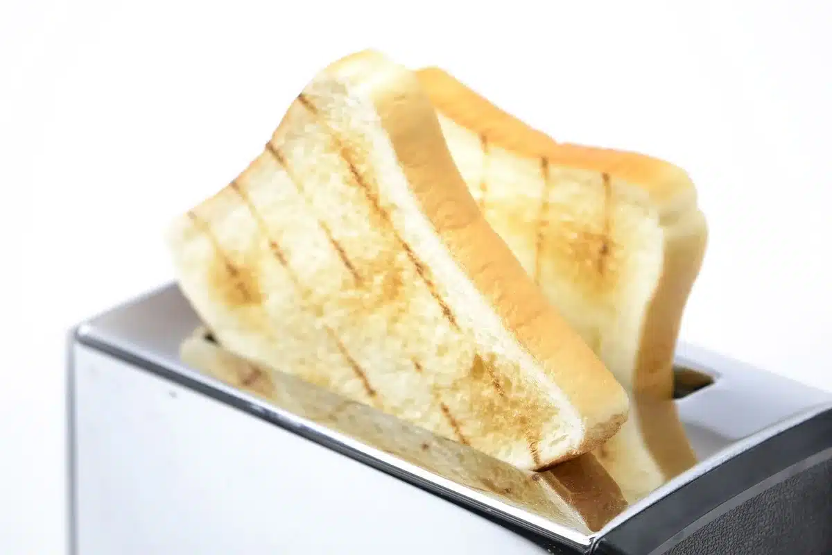 Tranches de pain sur une planche près d'un grille-pain, cuisine en plein jour