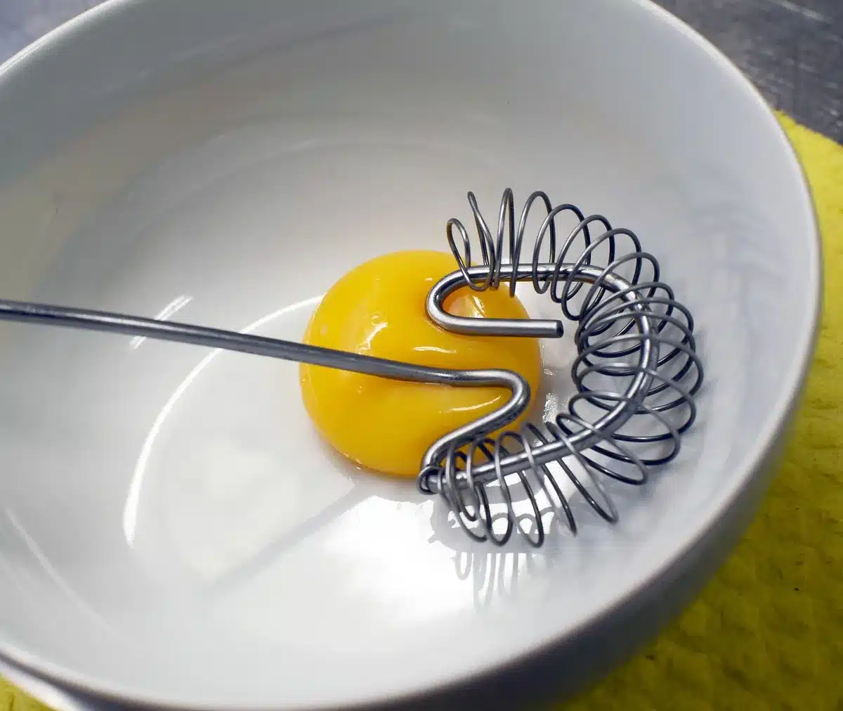 Bol et fouet pendant la préparation d'une sauce hollandaise maison