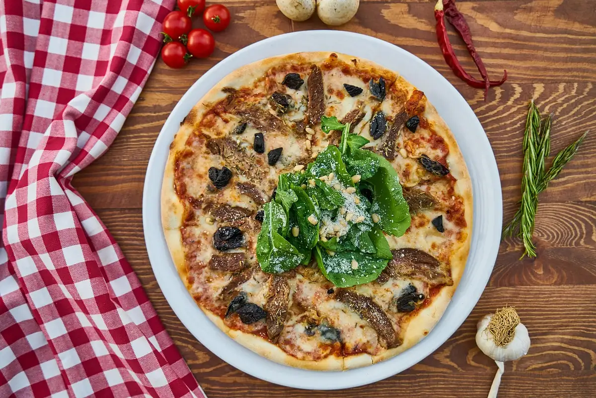Poêle avec lard croustillant, épinards et ail en train de revenir