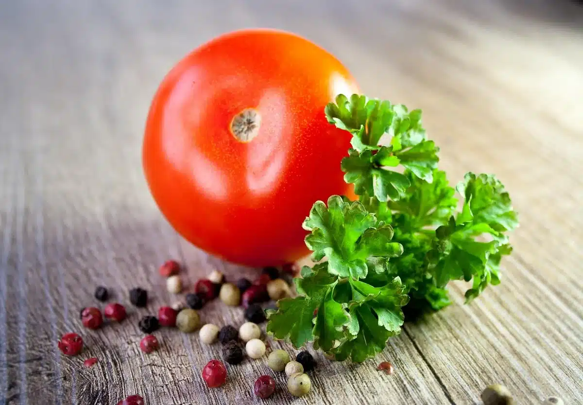 Découpe des légumes sur une planche à côté d'un robot de cuisine