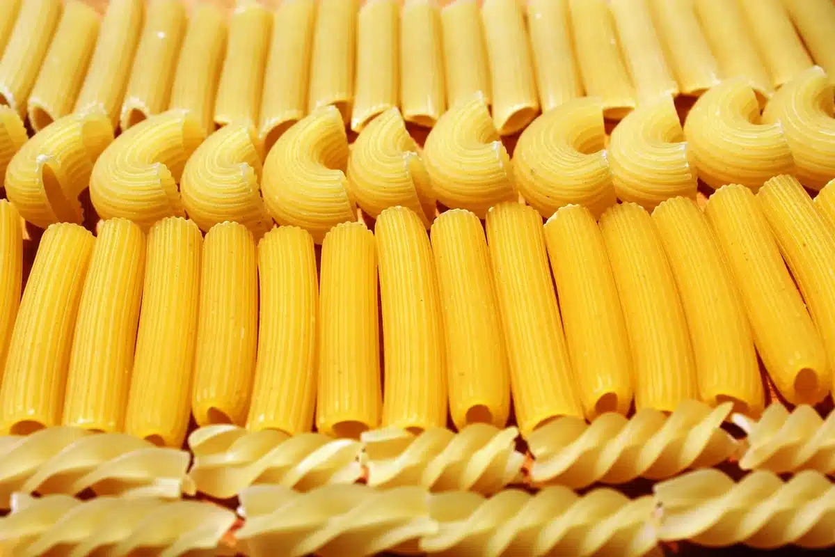 Ingrédients disposés: pâtes, crème, fromage, noix et persil sur une table