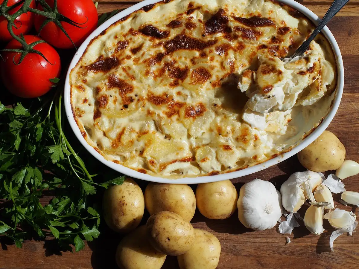 Plat à gratin au four avec piquillos nappés de béchamel prêts à gratiner