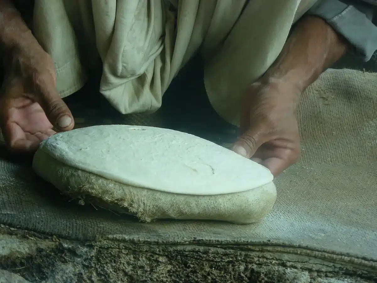 Tarte flambée dorée et croustillante sortie du four sur une plaque