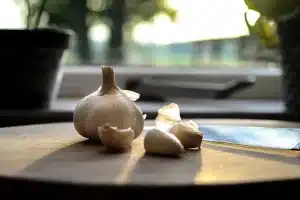 Pâte à flammekueche étalée sur une plaque avec ingrédients et mains préparant la tarte