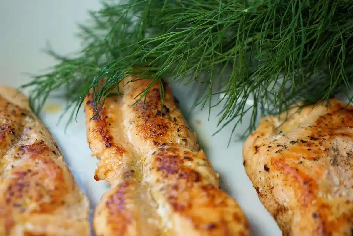 Étals de poisson avec filets blancs sur glace dans un marché en plein jour